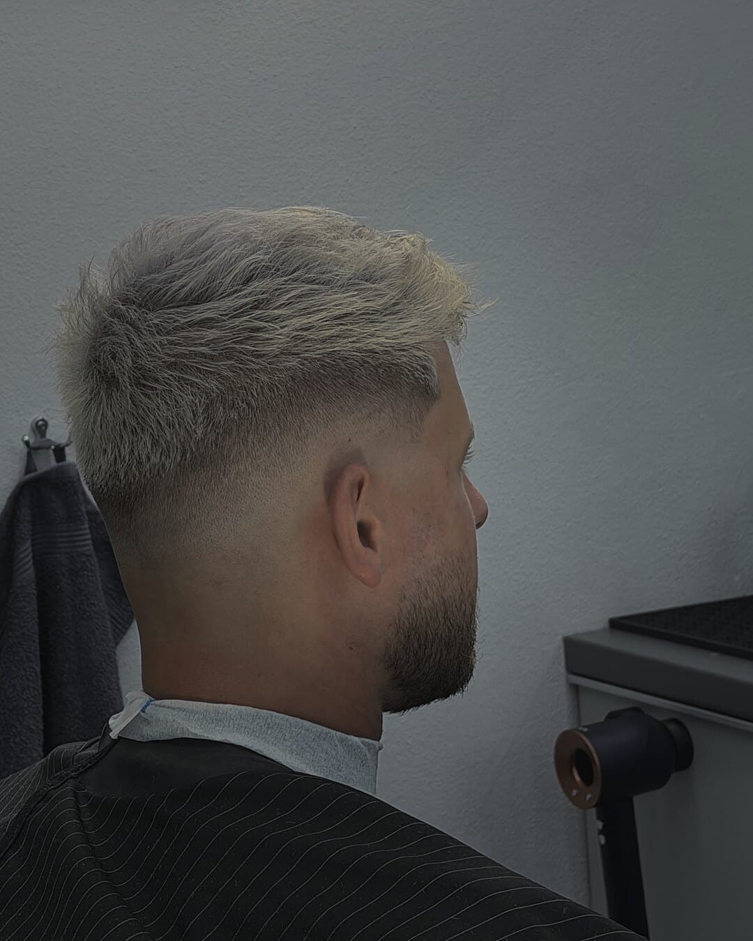 Svetlý skin fade s krátkym textúrovaným vrchom a bradou — strihal Ján