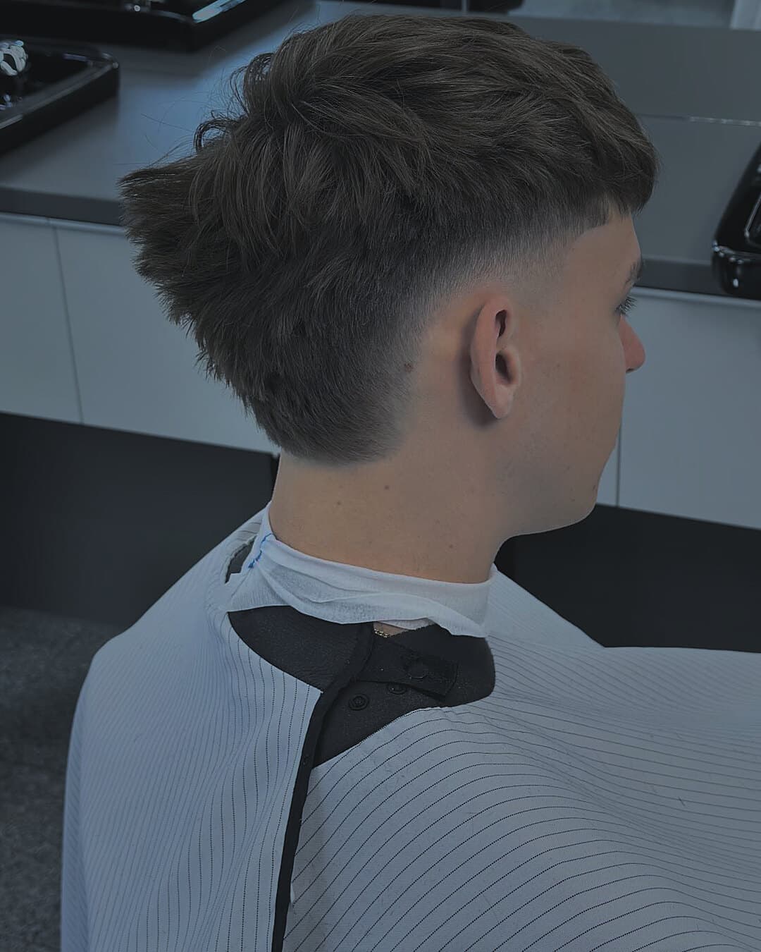 Burst mohawk crop — hrebeň dĺžky v strede, burst fade okolo ucha, profil — strihal Marek